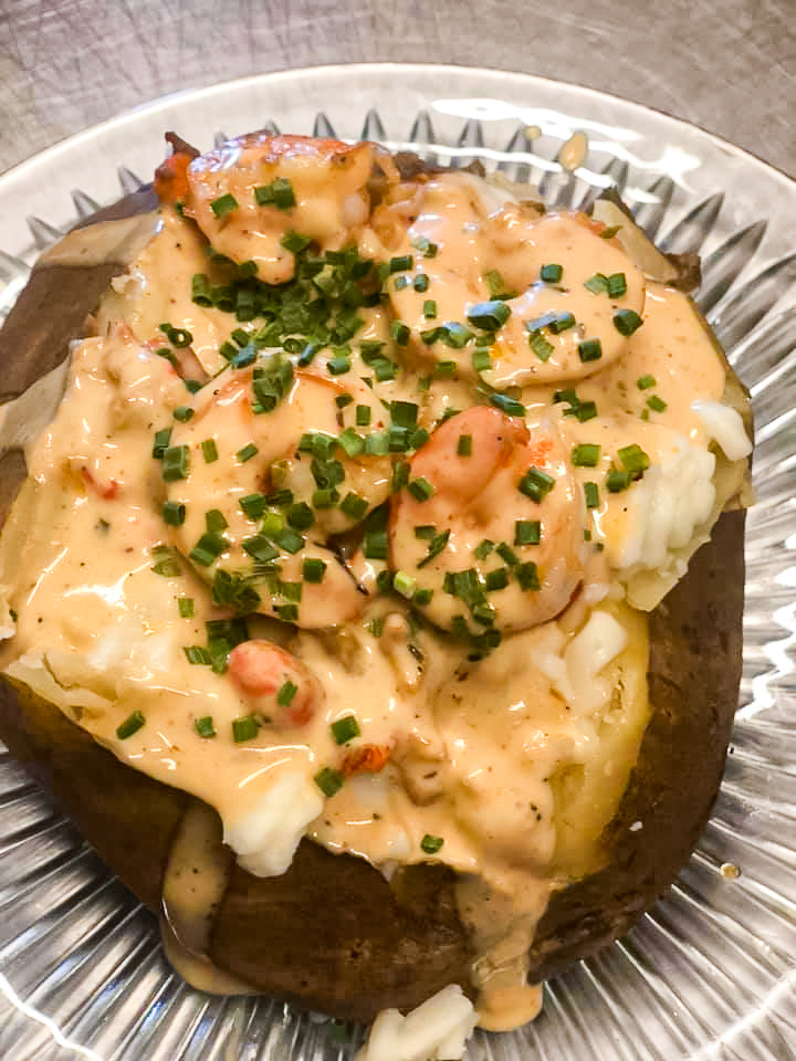 Shrimp stuffed baked potato with melted cheese